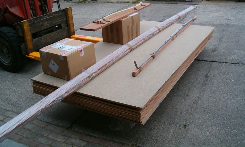 Bouwpakket Lobster 12,5 op pallet: stapel gefreesde platen, dozen epoxy, massief hout en gelamineerde helmstok